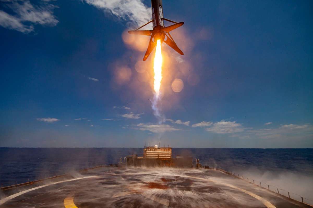 A Falcon 9 reusable rocket landing vertically after a successful mission.