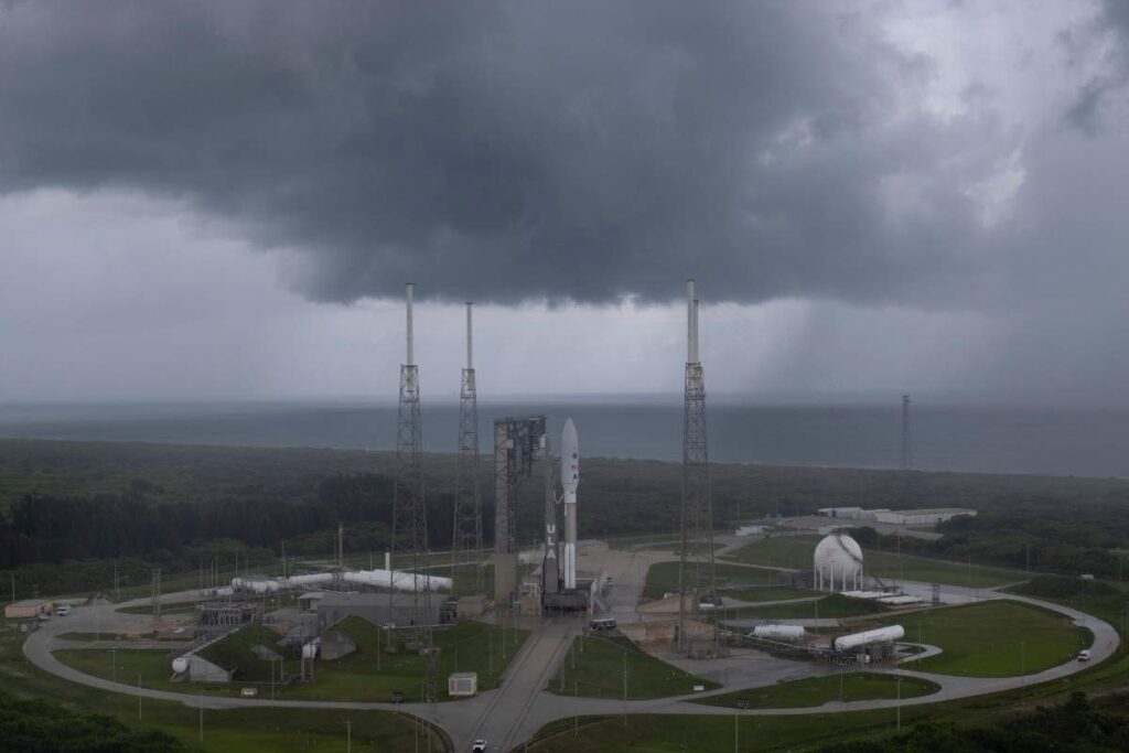Rocket Launching Vs Weather-Rocket standing on launch pad under cloudy sky before launch.